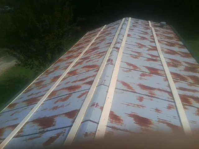 Rusted metal roof panels with new wood purlins before replacement — Storm Damage Roof Repair in Morganza by Roofing Brothers