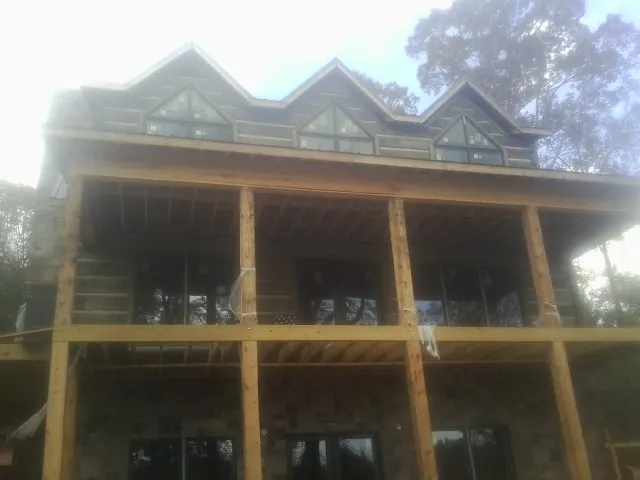 Dormers and porch framing on a large log home under construction — Roof Coating work by our crew in Morganza