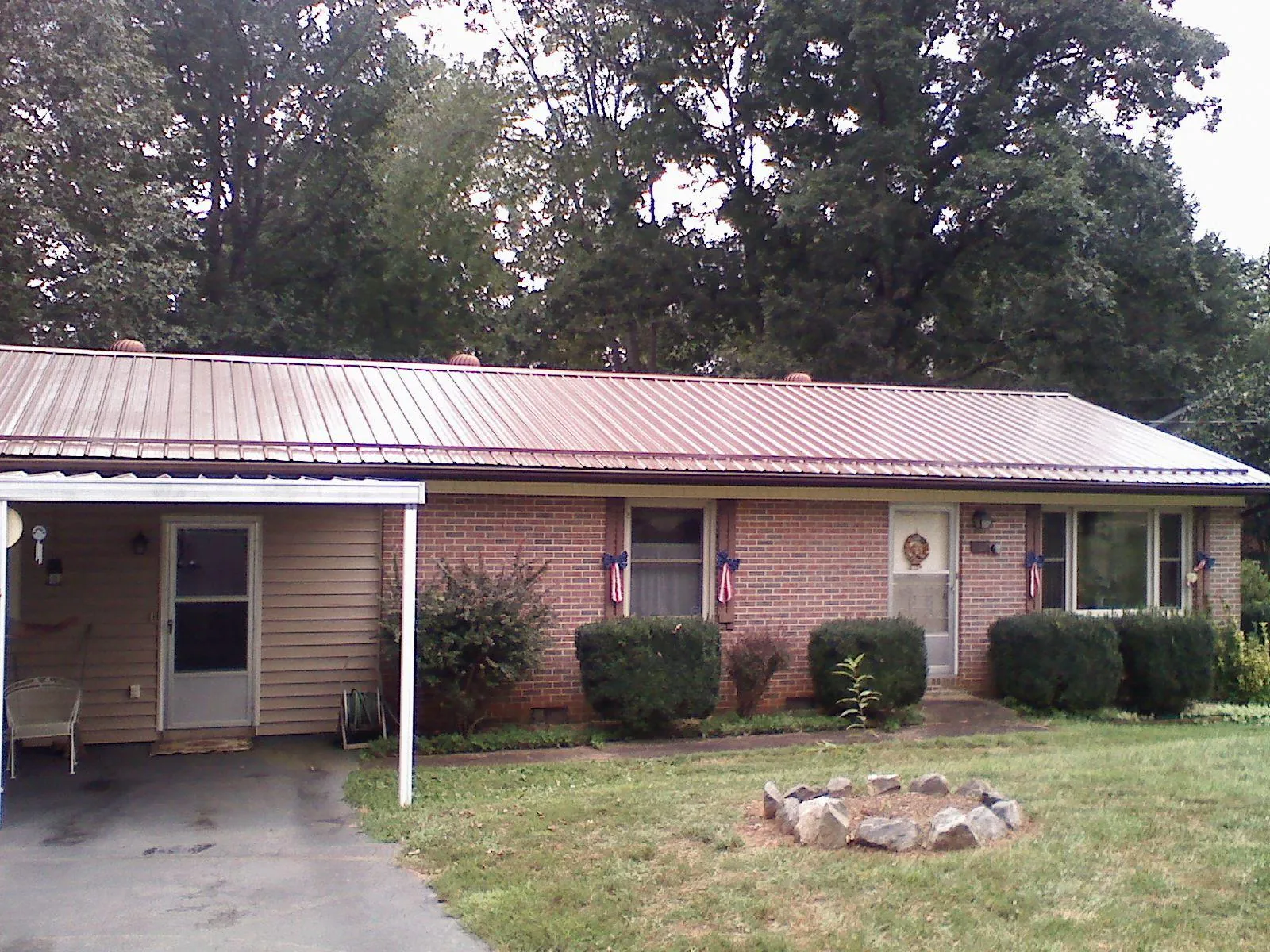 Bronze metal roof and carport on a brick ranch home — Roof Repair work by our crew in Morganza